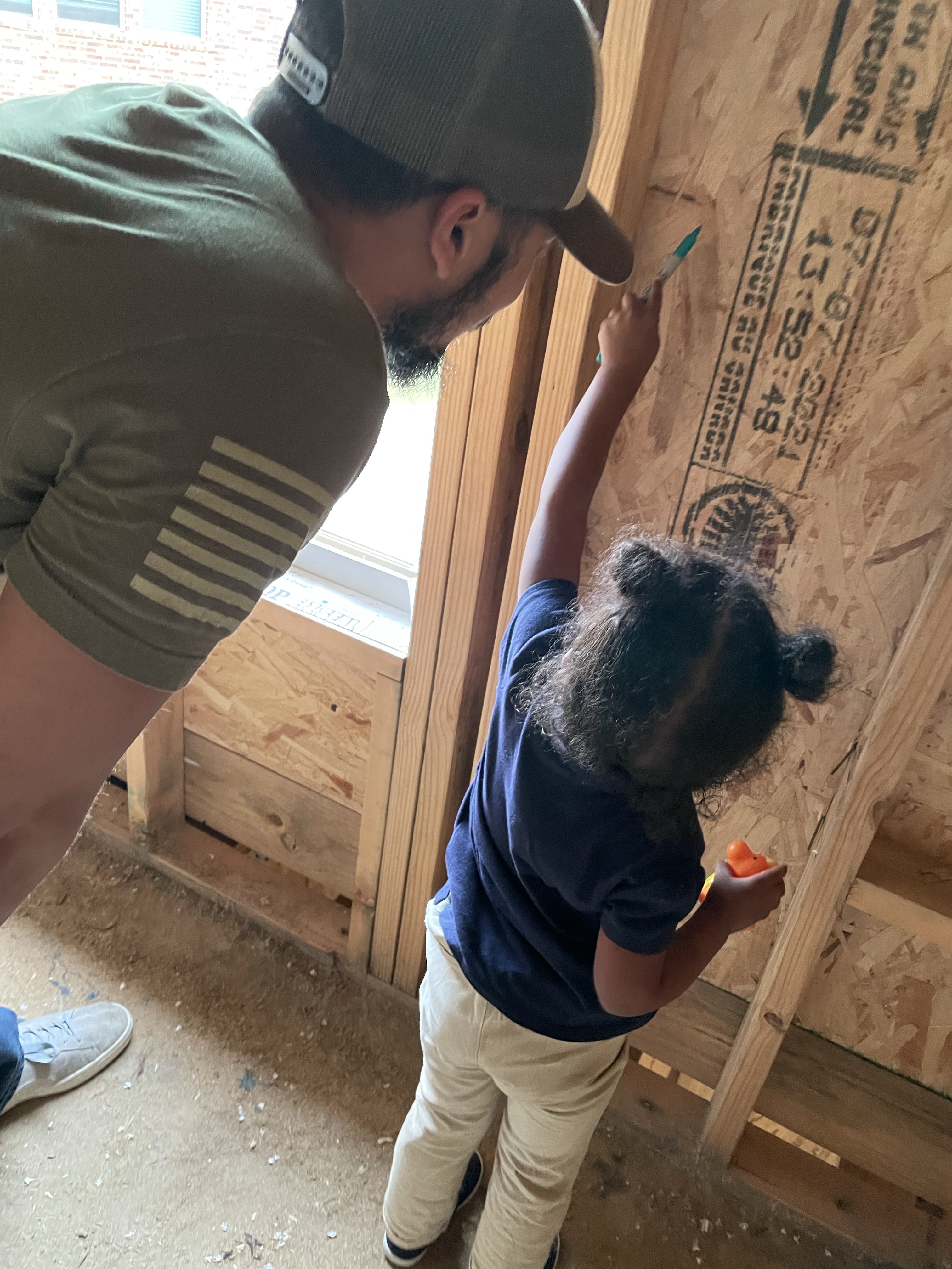 new-home-daddy-daughter-writing-on-the-foundation